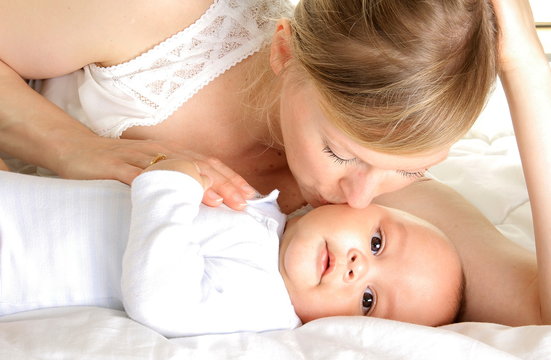 baby been kissed by his mother and been cared for after having a good sleep in bed at home stock photograph stock photo