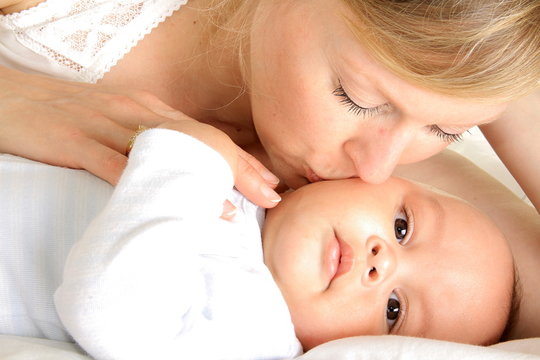baby been kissed by his mother and been cared for after having a good sleep in bed at home stock photograph stock photo
