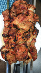 Grilled on fire pieces of meat kebab or barbecue close-up. It looks delicious. Kebab - pieces of pork and strung on skewers.