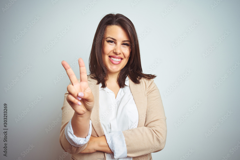 Sticker young beautiful elegant business woman over isolated background smiling with happy face winking at t