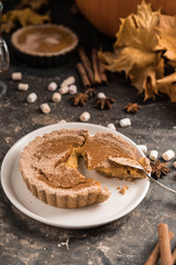 Yellow pumpkin pie orange  pumpkins with yelllow dry autumn leaves decor on dark table background.Harvesting,autumn and Thanksgiving concept