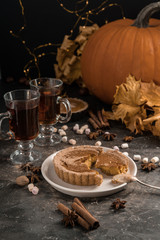 Yellow pumpkin pie orange  pumpkins with yelllow dry autumn leaves decor on dark table background.Harvesting,autumn and Thanksgiving concept