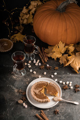 Yellow pumpkin pie orange  pumpkins with yelllow dry autumn leaves decor on dark table background.Harvesting,autumn and Thanksgiving concept