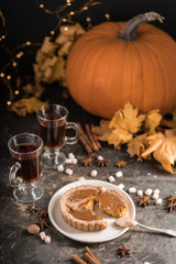 Yellow pumpkin pie orange  pumpkins with yelllow dry autumn leaves decor on dark table background.Harvesting,autumn and Thanksgiving concept