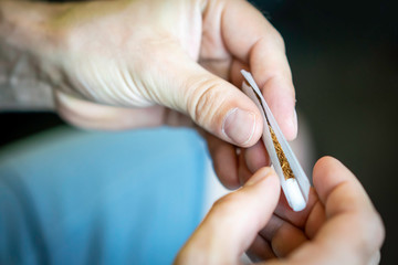 Male hands rolling up a tobacco cigarette