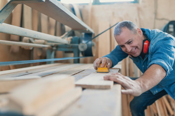 Attractive man doing woodwork in carpentry