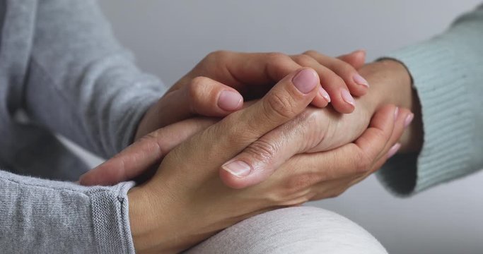 Close up view of young woman hold old female hands