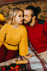 Sweet family couple have picnic in autumnal park. Man and woman sitting on picnic blanket. Bicycle ride and active lifestyle. Romantic picnic concept