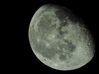 a close-up of the waning three-quarter moon in the starry night sky