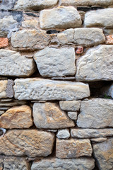 Soft stone block wall with large gaps and cracks 