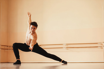 Male ballet dancer practicing choreography at dance studio.