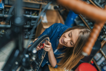 Fototapeta na wymiar Young woman repairing bicycle