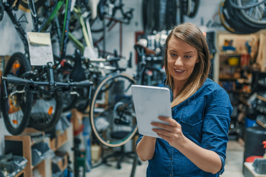 Female mechanic at work. Verify the checklist. Mechanic woman checking something on a tablet-pc and checklist.