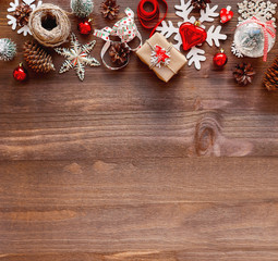Christmas and New year wooden background with present in craft paper, ribbons, decorations. Top view, flat lay with copy space.