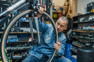 Fototapeta na wymiar Bike mechanic repairing a wheel