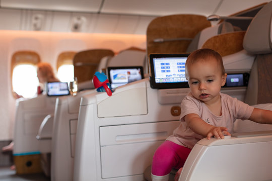 Toddler girl discovering her business class seat