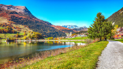 Fototapeta na wymiar Bright autumn view of San Valentino village and Muta lake (Haidersee)