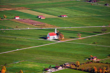 Aerial view of famous white St. Coloman pilgrimage church in autumn