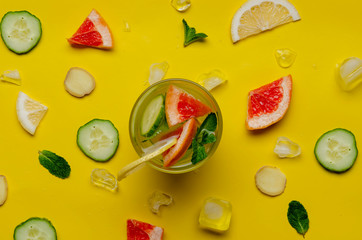 Bottles of fresh detox water on colorful background