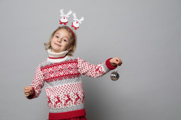 Funny kid with Christmas band. Cheerful smiling little girl .