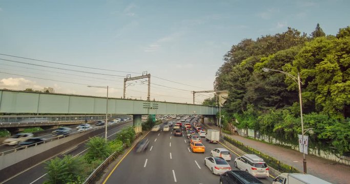 Time lapse of cars on the road and train on railr bridge with clear sky and forest.