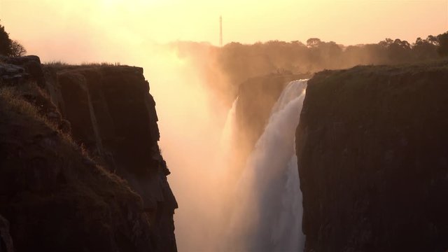 Waterfalls with Golden Sun And Cliffs, Africa Beautiful shot of Waterfalls in Golden Hour with mist, Victoria falls,  Zimbabwe