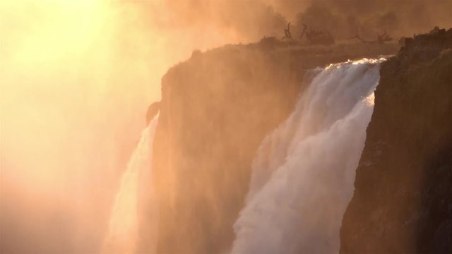 Waterfalls with Golden Sun And Cliffs, Africa Beautiful shot of Waterfalls in Golden Hour with mist, Victoria falls,  Zimbabwe