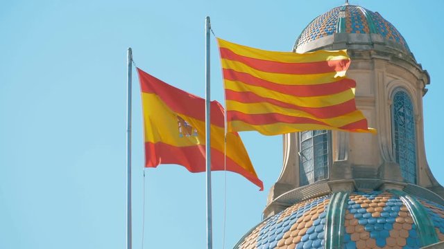 Independence,Nationalism.Spanish and Catalan flags waving in square of Catalonia