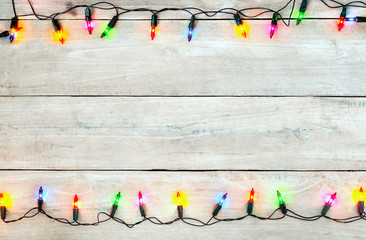 Christmas lights bulb frame decoration on white wood. Merry Christmas and New Year holiday...