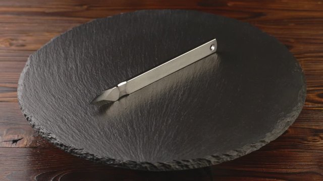 Custom hand crafted japanese kiridashi marking knife for carpenter on the turning slate board table. Polished surface