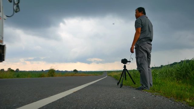  Photographer takes a photo nearby highway road when cloudy and raining