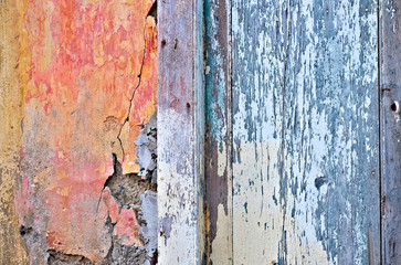 Detail of an old colorful weathered wall and aged timber door, beauty of vintage abandoned homes.