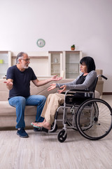 Old husband looking after disabled wife