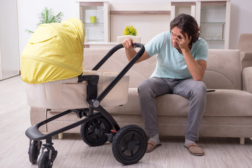 Young man looking after baby in pram