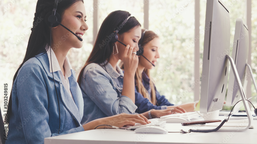 Aufkleber customer support agent or call center with headset works on desktop computer while supporting the cu