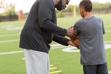 American Football coach training a young athlete.