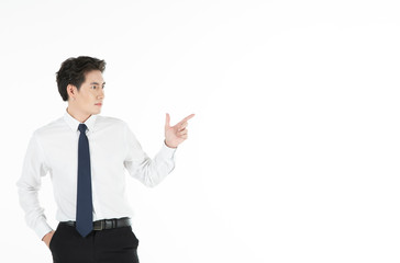 Portrait of confident man smiles, arms in pocket, points finger to the right, isolated on white background with copy space. For motivation, finance, business, achievement and entrepreneur concept