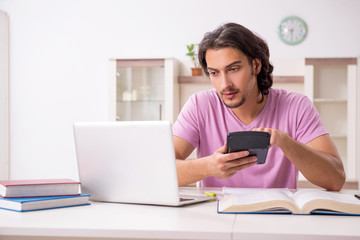Young male student preparing for exams at home