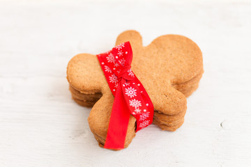 Gingerbread cookie man on white wood background. Winter background