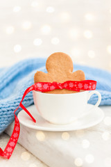 Gingerbread cookie man in white cup. Winter background