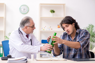 Young male alcoholic visiting old doctor