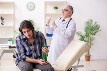 Young male alcoholic visiting old doctor