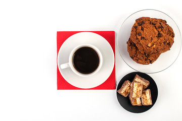 White cup of black coffee on a red napkin.