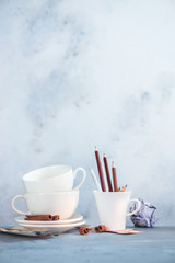 Coffee cup with pencils on artist workplace, creative concept on a light background with copy space