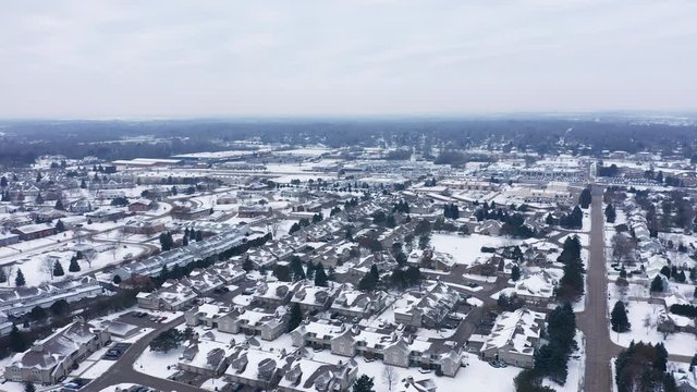 Aerial view of residential houses covered first snow. American neighborhood, suburb. Real estate, drone shots, day time, winter, from above