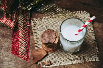 Stack of tasty chocolate biscuits cookies and a glass of milk on table