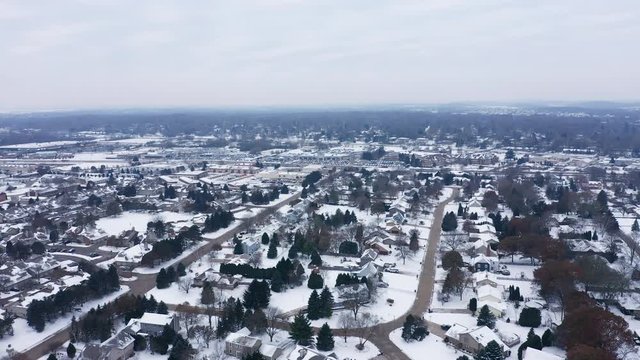 Aerial view of residential houses covered first snow. American neighborhood, suburb. Real estate, drone shots, day time, winter, from above