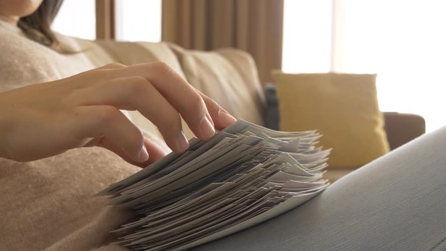 a woman sitting on a sofa and looking at photos and pictures