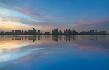 City Skyline By River Against Sky at twilight.