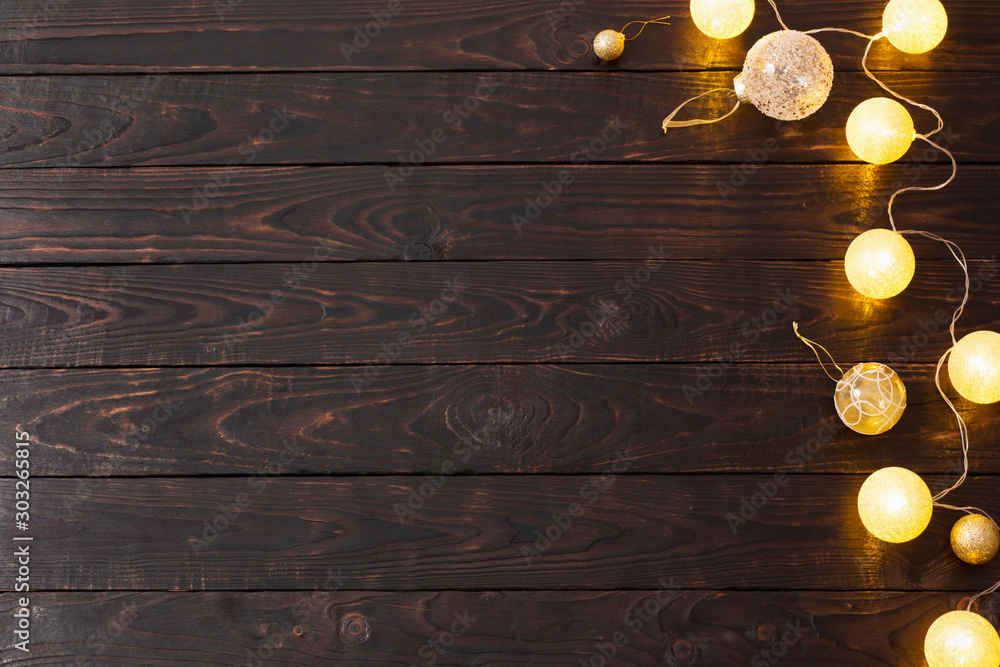 Poster Christmas golden lights on dark wooden background